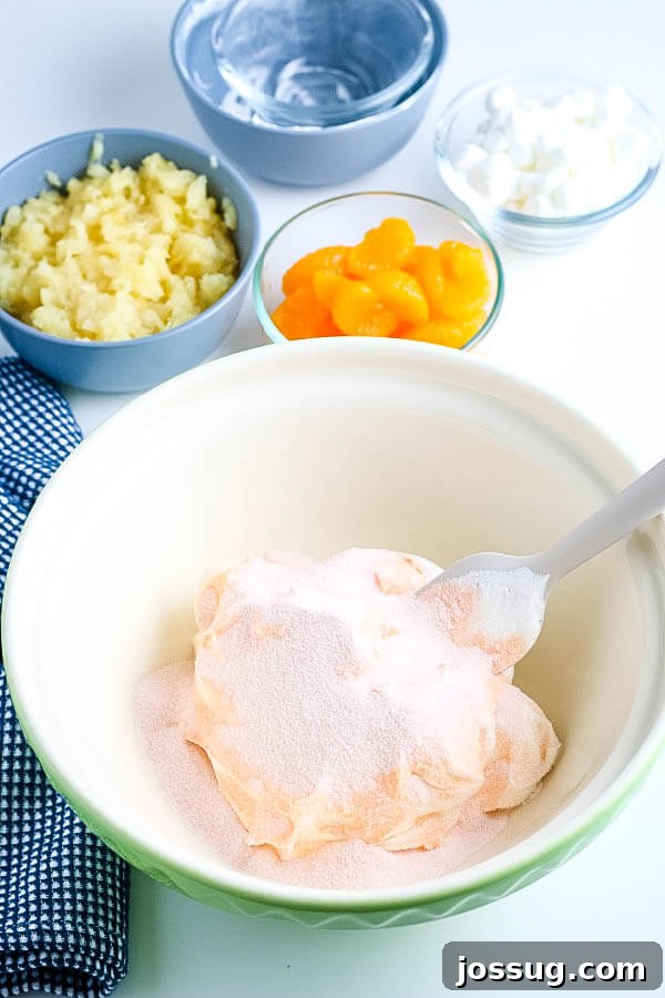 Creamsicle Dream Dessert 5 jello powder sprinkled over whipped topping in a large mixing bowl