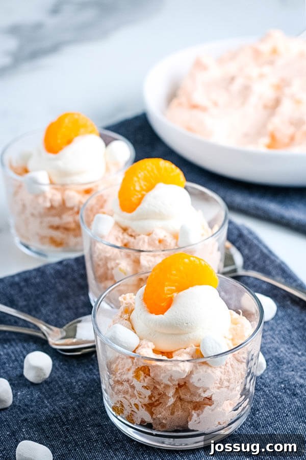 Creamsicle Dream Dessert 9 finished fluff salad in individual serving bowls, garnished with whipped cream and an orange segment