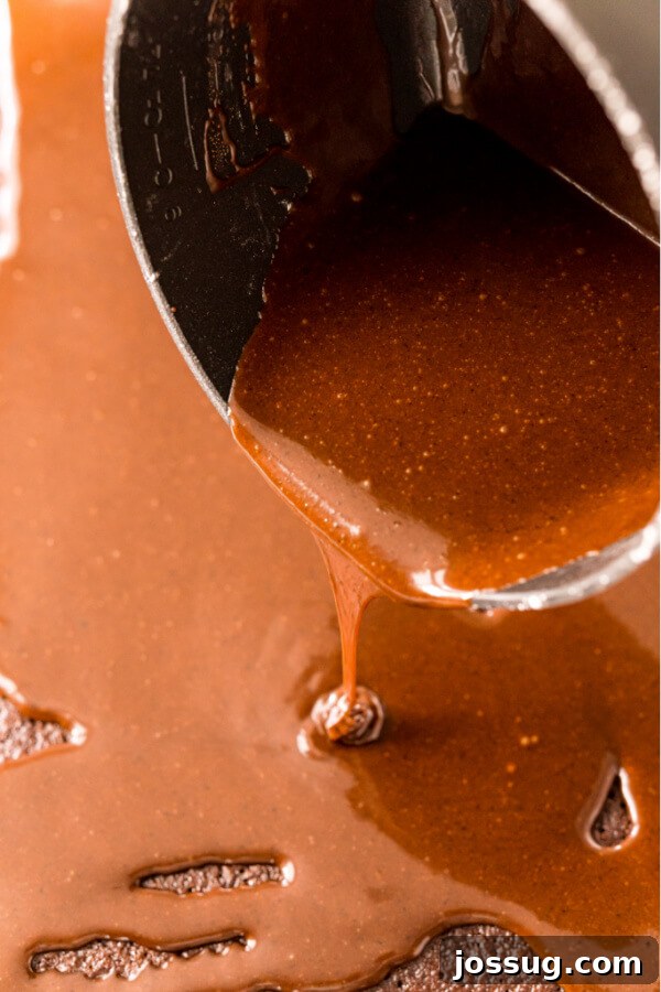 Lone Star Chocolate Slab 3 Warm fudgy frosting being poured generously over a freshly baked Texas Sheet Cake