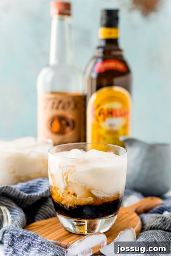Velvet Russian 6 Finished White Russian Cocktail with alcohol bottles blurred in the background