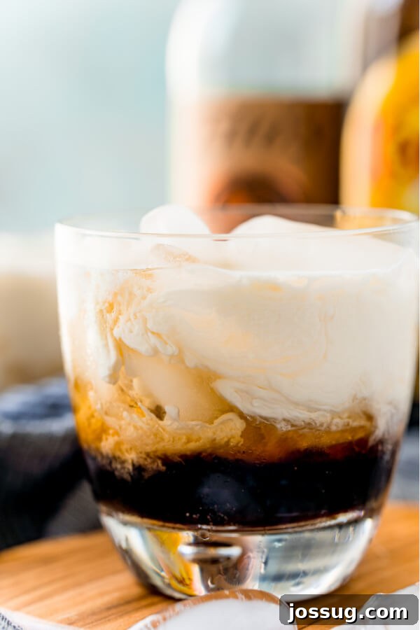 Velvet Russian 7 Close-up of a finished White Russian cocktail in a glass over ice, showing the beautiful layers