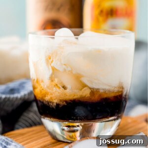 Velvet Russian 9 Closeup of a White Russian cocktail with alcohol bottles blurred in the background
