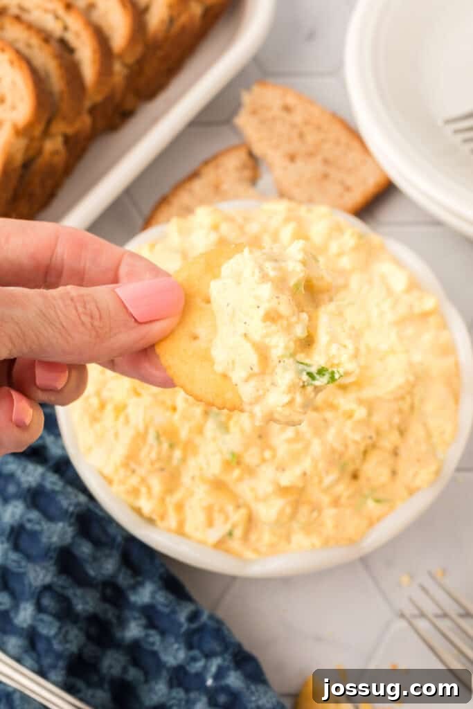 Egg salad spread on a single cracker, ready to be eaten.