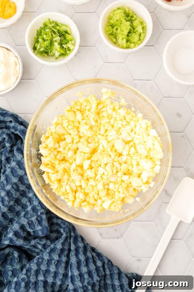 Step 4 of making egg salad: Peel and chop the hard-boiled eggs.