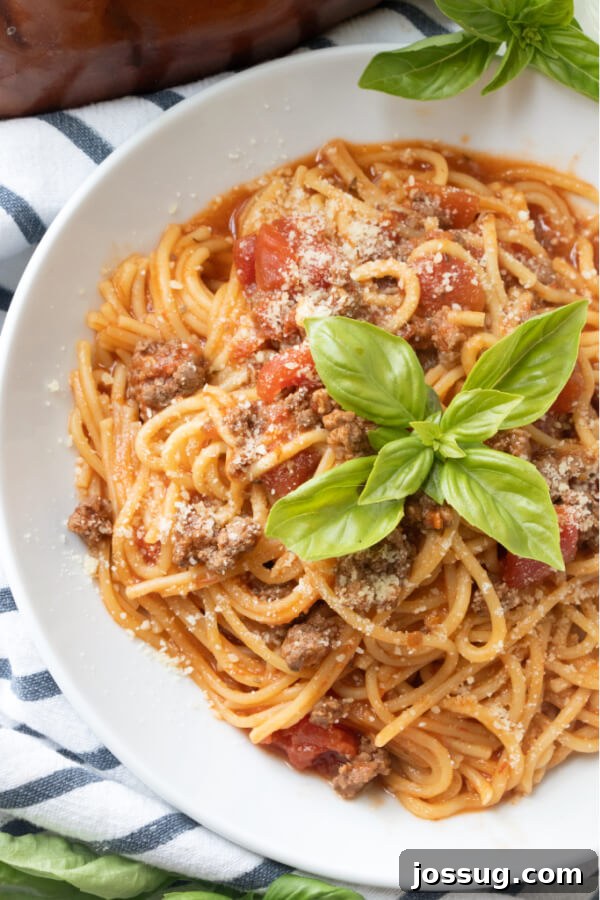 Finished Instant Pot Spaghetti in a bowl, garnished with fresh basil, ready to be served.