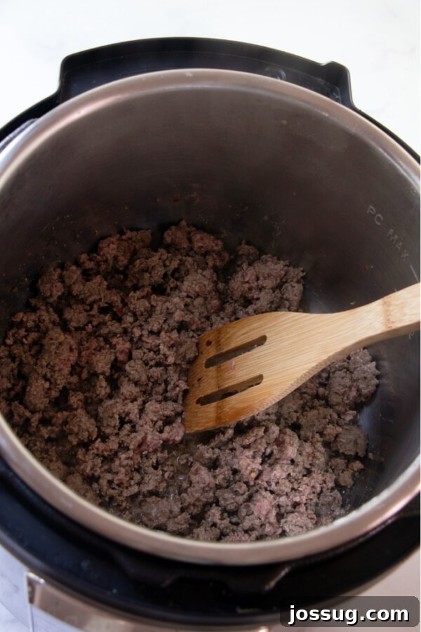 Ground beef and seasonings browning in the Instant Pot, preparing for the spaghetti sauce base.