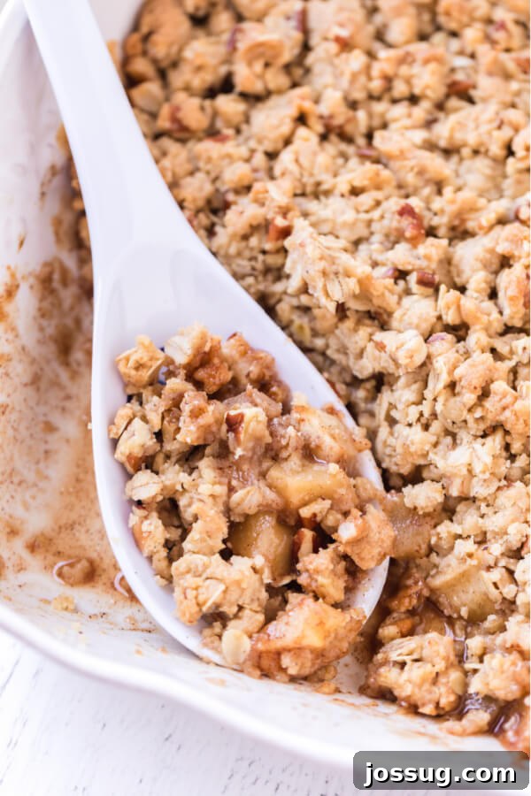 spoon of apple crumble resting in dish