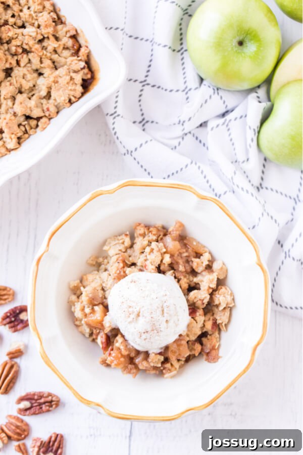 apple crumble in bowl with scoop of ice cream