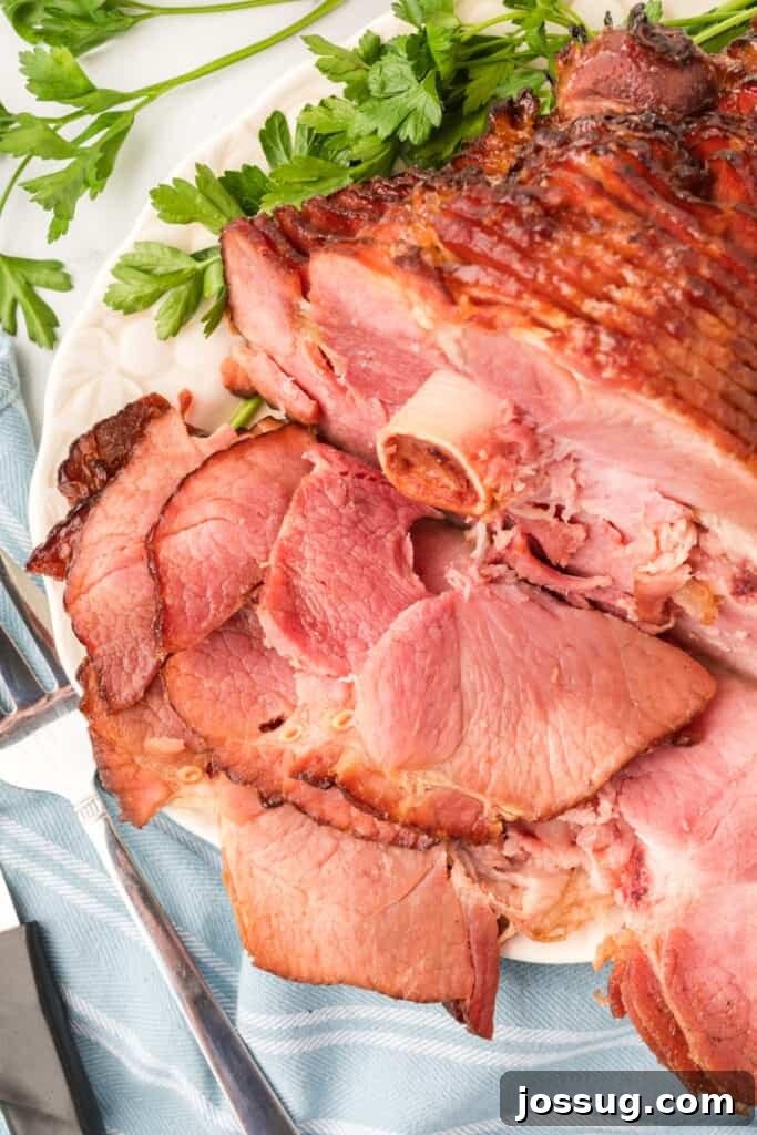 Close-up of a perfectly cooked spiral ham, showing the glistening glaze