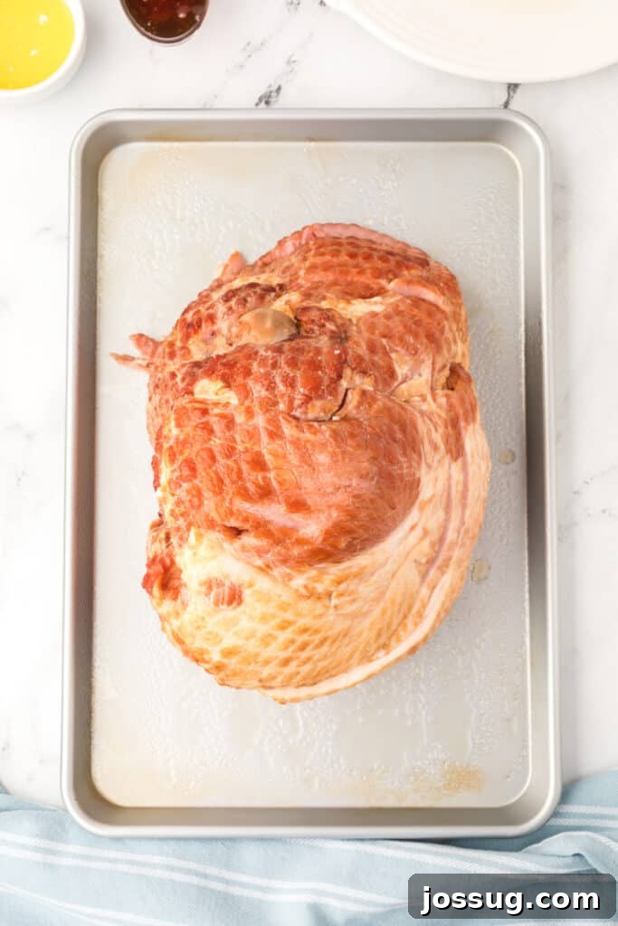 Preheat the oven to 350°F. Coat an oven roasting pan or 9x13-inch baking dish with cooking spray. Place the ham in the pan, cut side down.