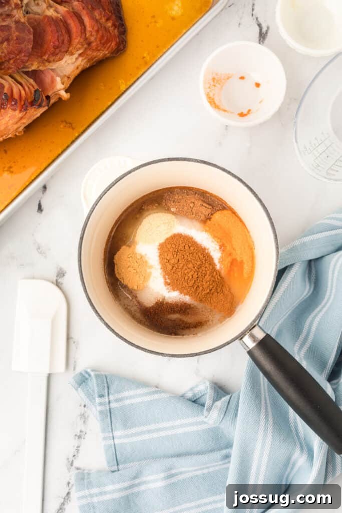 In a medium saucepan, combine sugar and all seasonings with 1/2 cup water. Bring the sugar mixture to a boil over medium-high heat, stirring frequently until the sugar is dissolved.