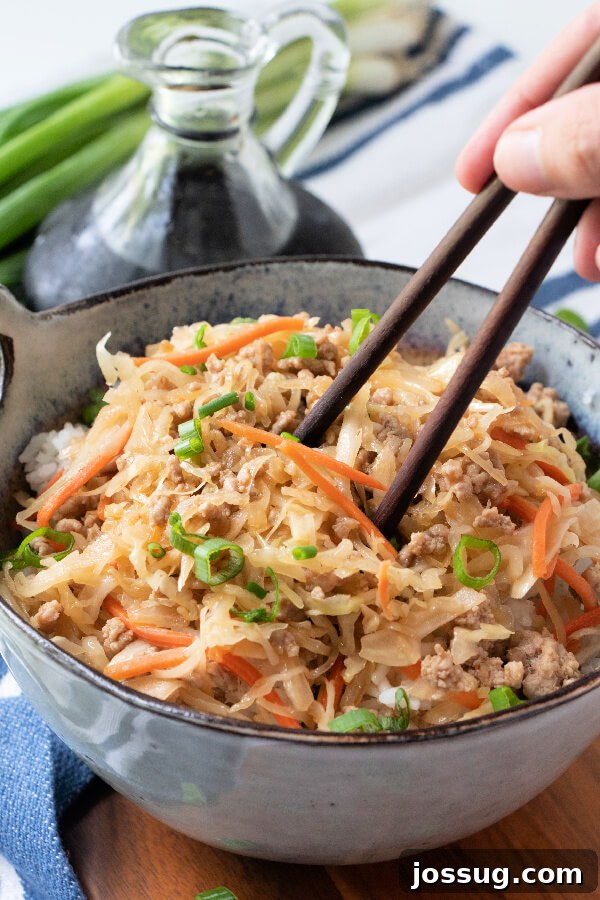 Enjoying Egg Roll in a Bowl with Chopsticks A person using chopsticks to pick up a mouthful of Egg Roll in a Bowl from a white bowl.