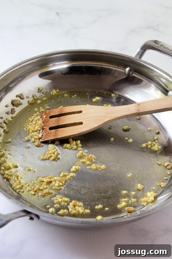 Sautéing Garlic for Egg Roll in a Bowl Garlic being cooked in olive oil in a large skillet or wok.