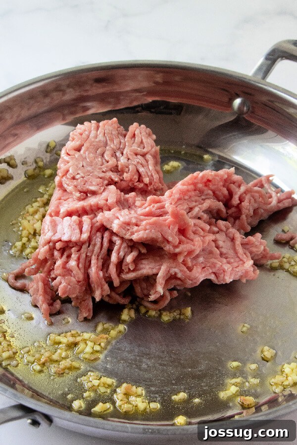 Browning Ground Pork for Egg Roll in a Bowl Ground meat (likely pork) being cooked and broken apart in a skillet or wok.