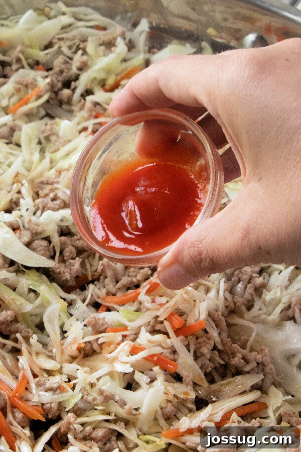 Adding Sriracha for a Spicy Kick Squirting Sriracha sauce into the skillet with other ingredients.