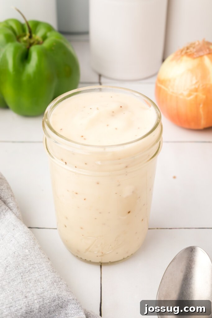 Homemade condensed cream soup substitute stored in a glass jar, showcasing its thick, creamy texture.