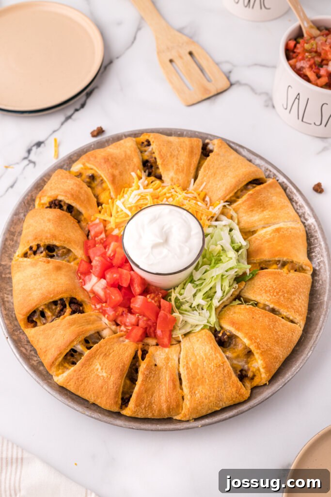 Cheesy Taco Ring Bake 2 Delicious taco ring with crescent rolls on a serving platter, garnished with fresh cilantro.