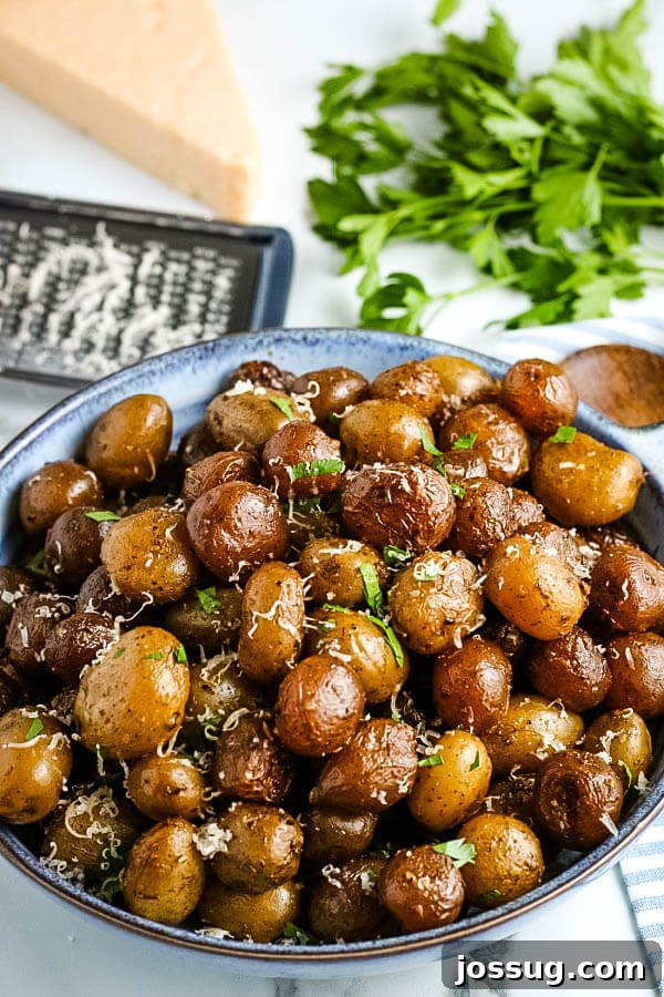 Slow Cooked Garlic Parmesan Potatoes 8 bowl of finished potatoes with fresh herbs, cheese wedge and grater in background