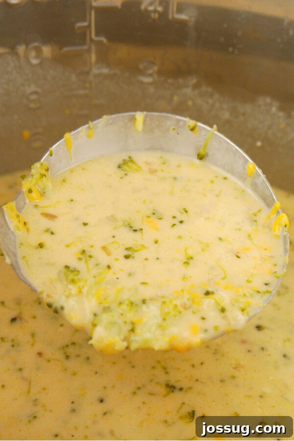 Velvety Instant Pot Broccoli Bliss 6 A close-up of a ladle serving a generous portion of finished Cream of Broccoli Soup, highlighting its rich, thick texture.