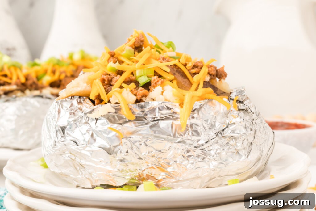 Idaho Spud Tacos 6 A large, golden baked potato generously filled with seasoned taco meat and cheese, ready to be topped.