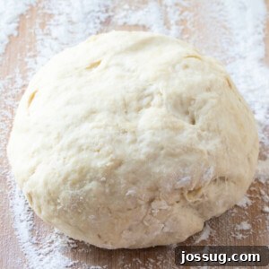 Close-up of a rustic homemade pizza dough, showcasing its texture before baking.