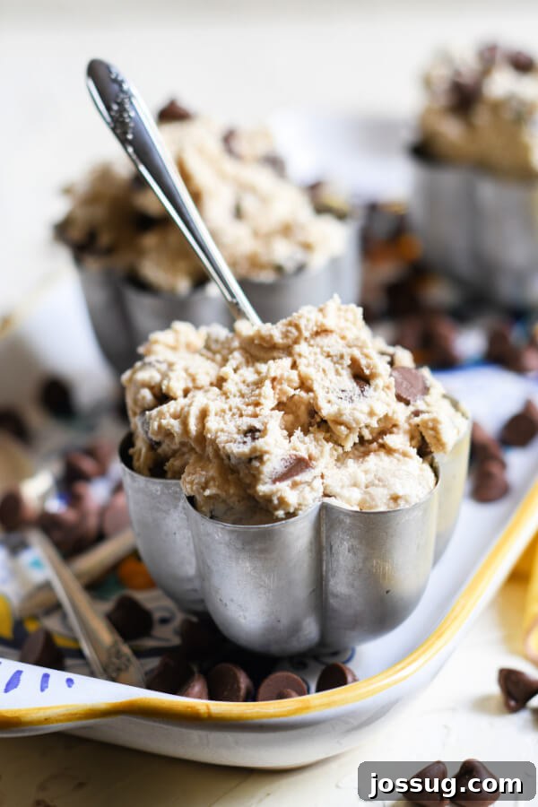 Close-up of a bowl of edible cookie dough with a spoon resting inside