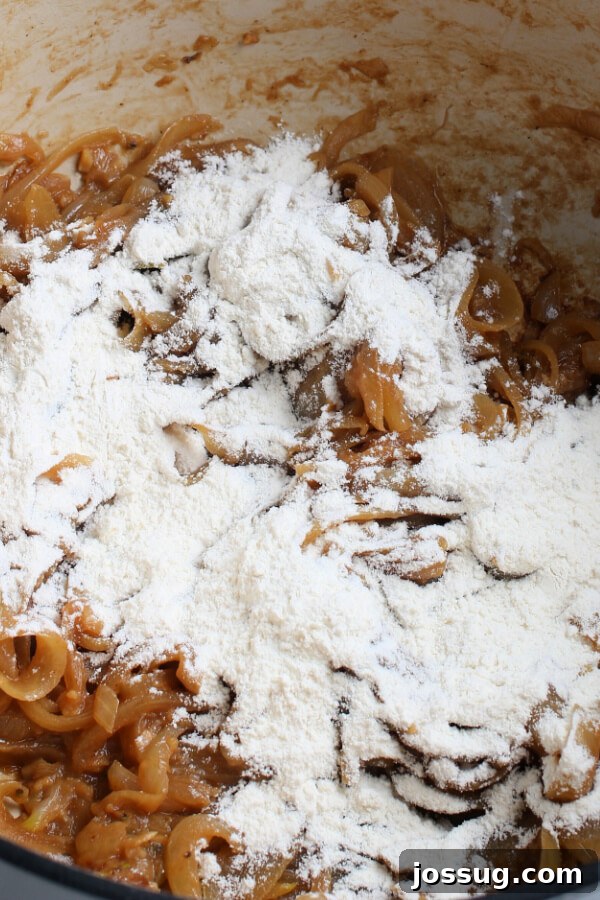 Golden Gratin French Onion Soup 6 All-purpose flour dusted over the caramelized onions in a pot, ready to be stirred in to form a roux.