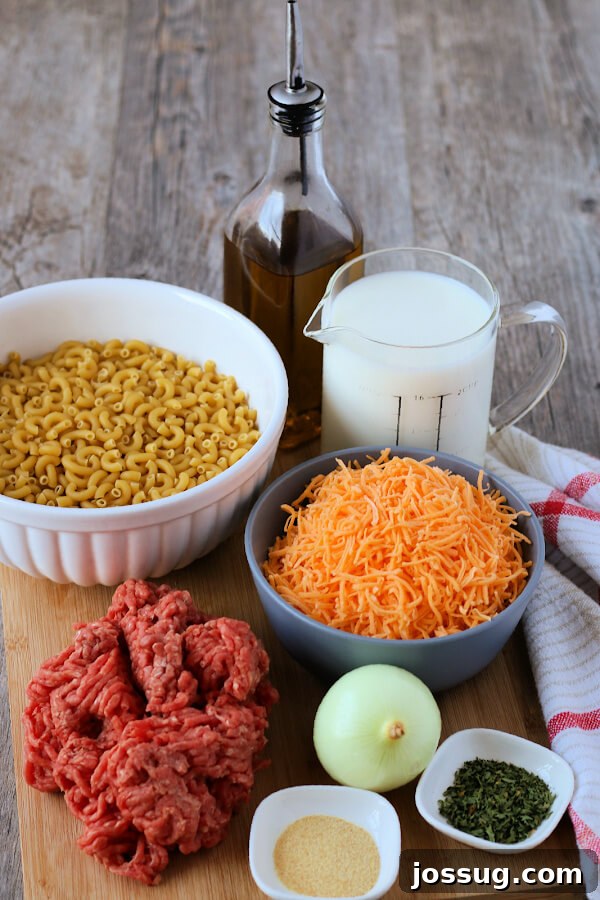 One-Pot Cheesy Beef Mac 3 Ingredients laid out for making homemade hamburger helper, including ground beef, macaroni, cheese, milk, and spices.