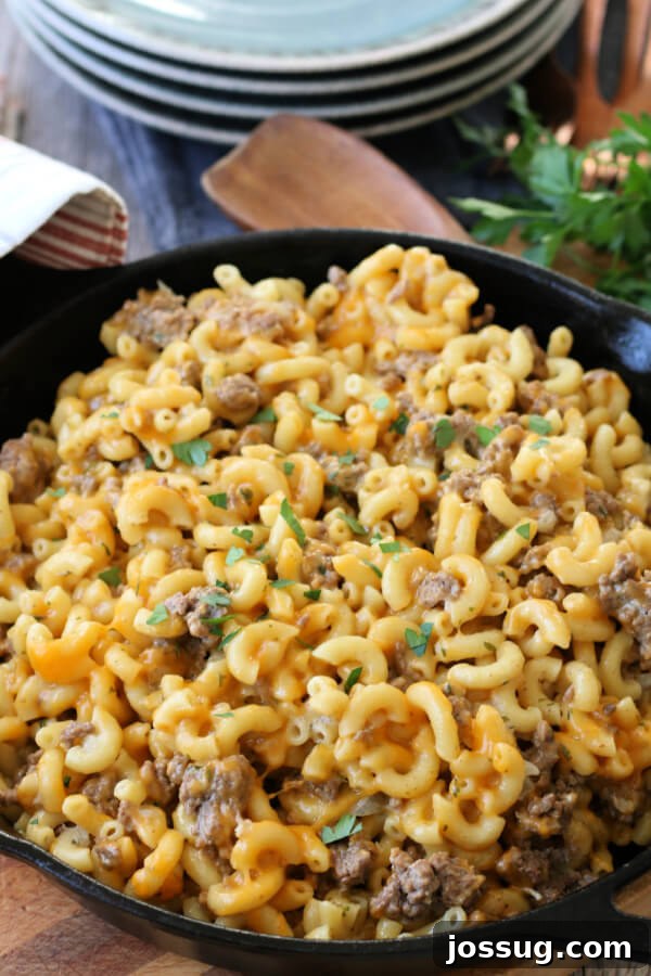 One-Pot Cheesy Beef Mac 9 Finished homemade Hamburger Helper in a cast iron skillet, garnished with fresh parsley.