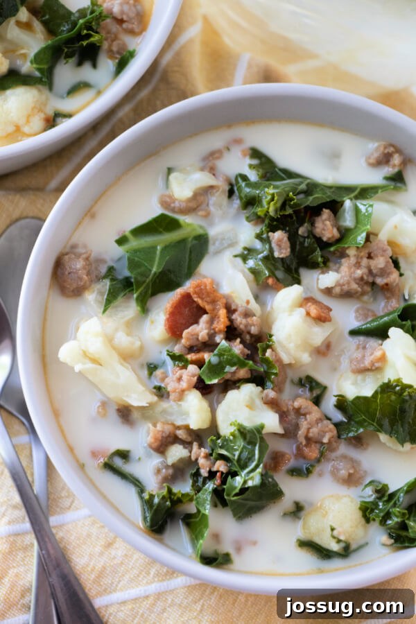 An overhead view of a single serving of Low Carb Zuppa Toscana soup in a ceramic bowl, garnished and ready to eat.