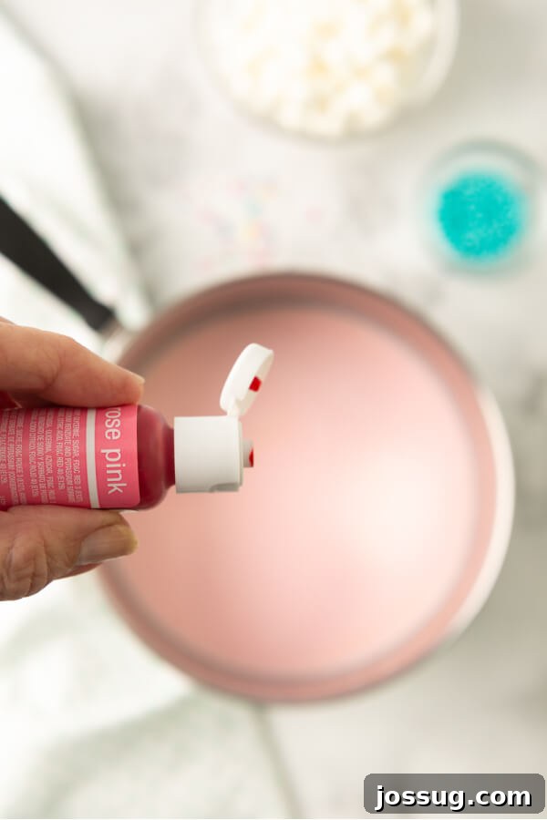 Rainbow Dream Cocoa 6 Adding a few drops of pink food coloring to the simmering milk and white chocolate mixture in a saucepan, infusing it with a magical hue.