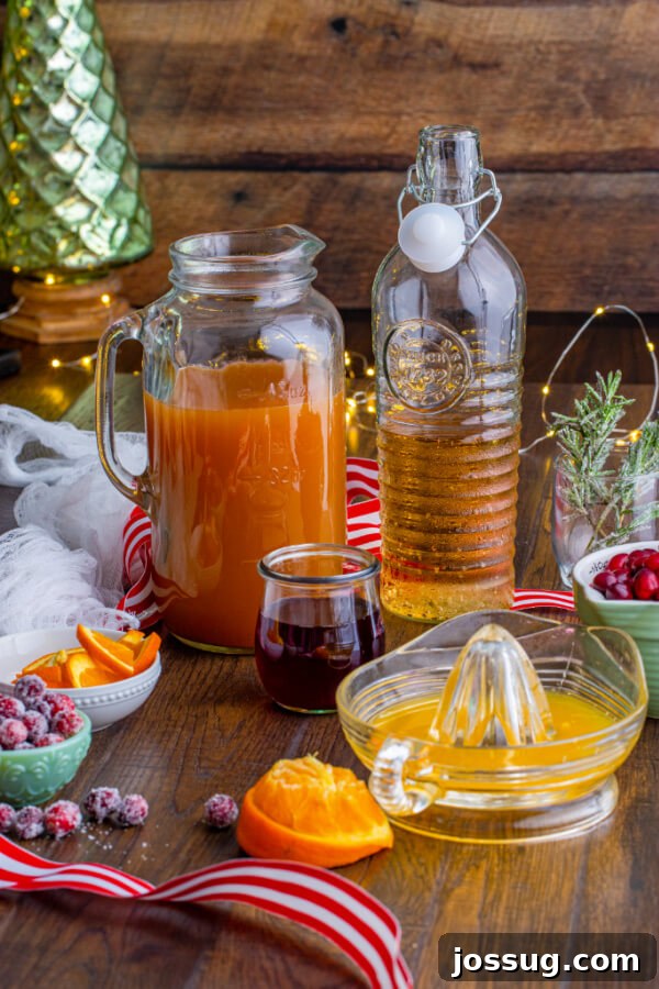 Ingredients for Christmas mocktail: cranberry juice, orange juice, apple cider, ginger ale, and ice
