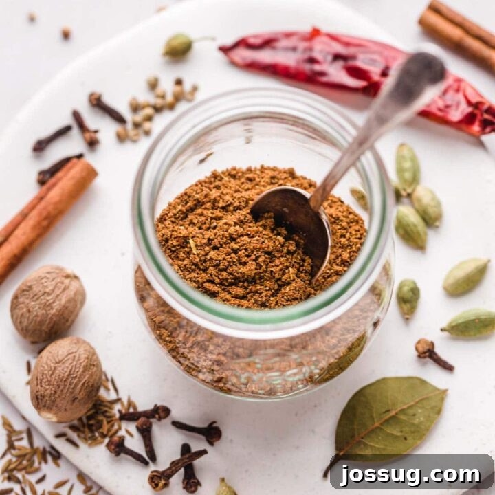Homemade Garam Masala spice mix in a bowl with a spoon, showing its vibrant colors.