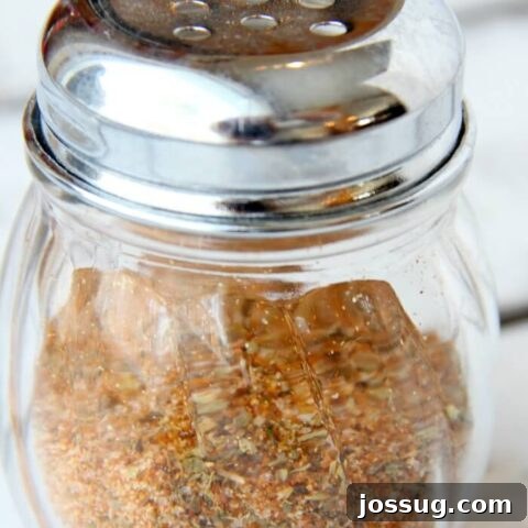 Chicken Dry Rub in a measuring cup, with whole spices visible.