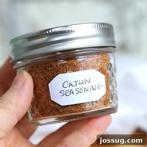 Cajun Seasoning mix in a small wooden bowl with a wooden spoon.
