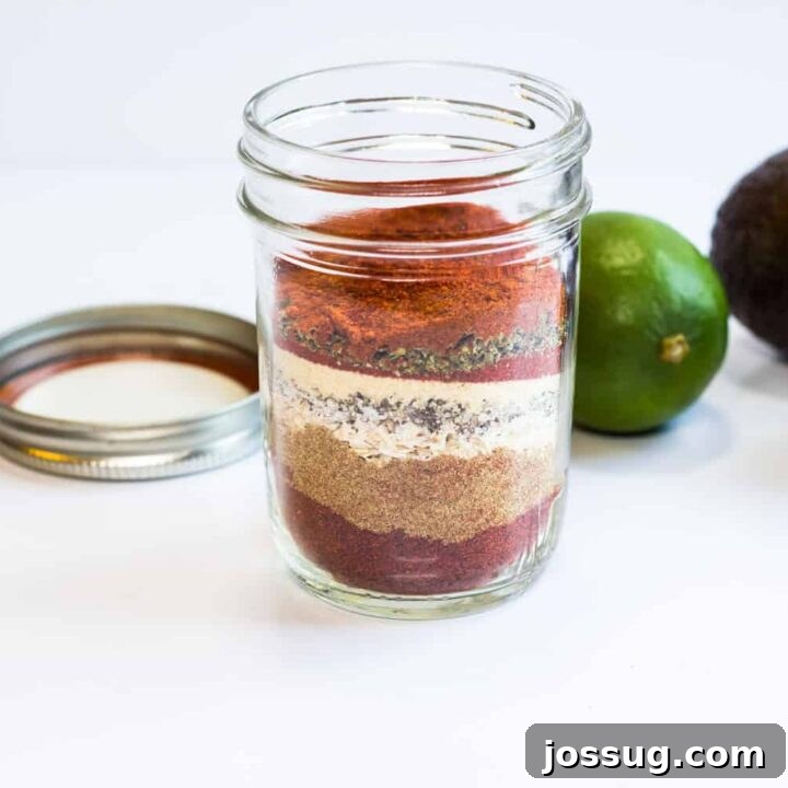 Keto Taco Seasoning in a small glass jar with a spoon, ready for use.