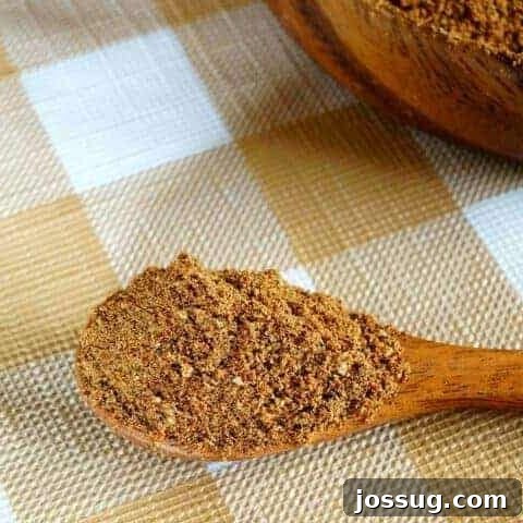Low Carb Taco Seasoning mix in a small wooden bowl with a spoon.