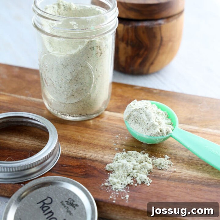 Homemade Ranch Seasoning mix in a glass jar, with a spoon for serving.
