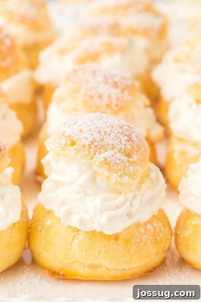 Pillowy Cream Dreams 22 A cluster of beautifully arranged cream puffs, showing their varied golden-brown hues and inviting textures, piled elegantly together.