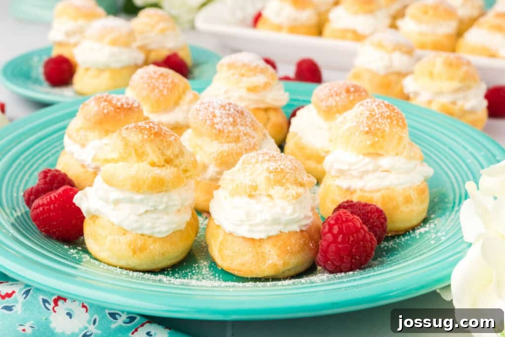 Pillowy Cream Dreams 23 A serene arrangement of cream puffs on a rustic teal plate, highlighting their inviting golden color and fluffy appearance.