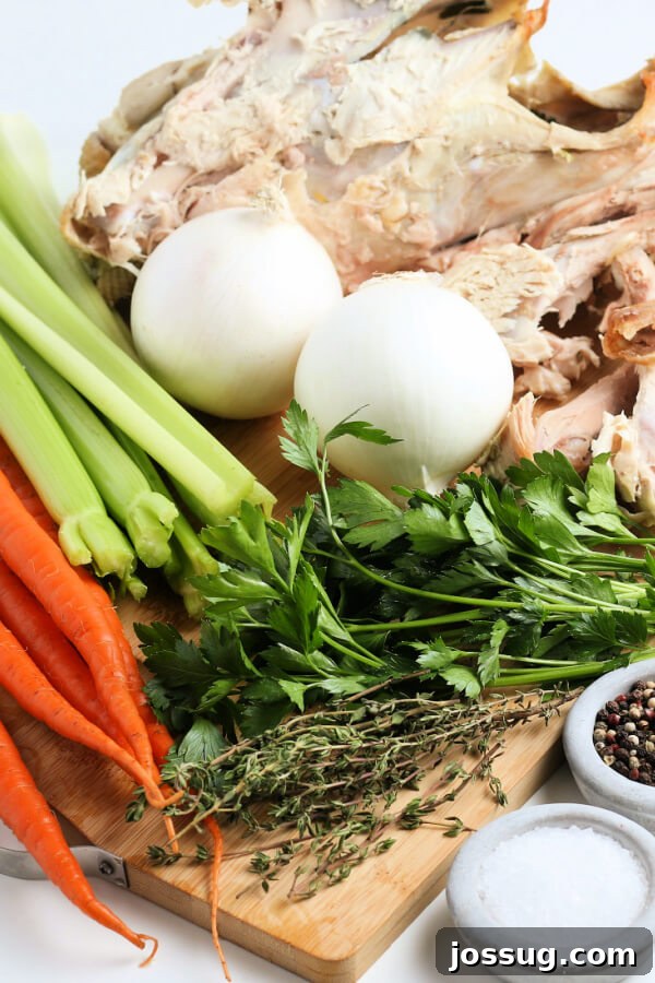 Rich Homemade Turkey Stock 3 Fresh ingredients like onions, celery, carrots, parsley, and thyme laid out next to a turkey carcass, ready for stock making.