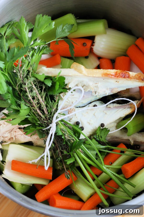 Rich Homemade Turkey Stock 4 Turkey carcass, chopped vegetables, and fresh herbs submerged in water in a large stockpot on the stovetop.