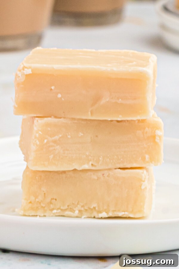 Decadent Baileys Irish Cream Fudge 2 Close-up of three pieces of rich Bailey's Irish Cream Fudge stacked on a plate, showcasing its creamy texture and inviting appearance.