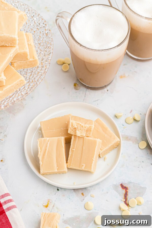 Decadent Baileys Irish Cream Fudge 7 Three pieces of Bailey's Irish Cream Fudge on a plate next to a cup of Irish cream coffee, suggesting a perfect pairing.