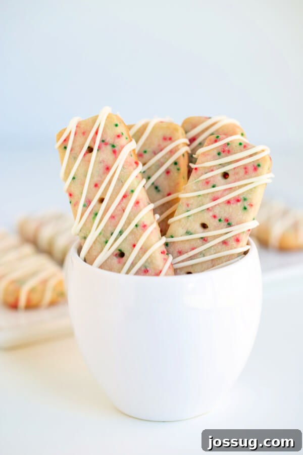 Christmas shortbread cookies in a small white bowl, dusted with powdered sugar.