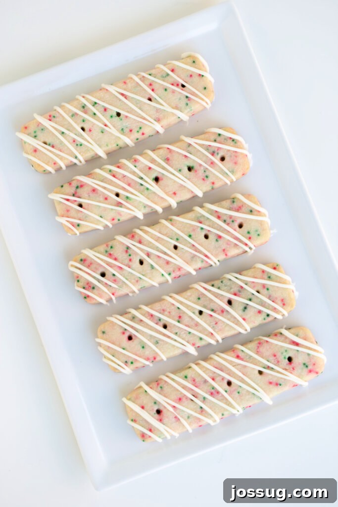 Assortment of shortbread cookie sticks on a white plate, showcasing different shapes.
