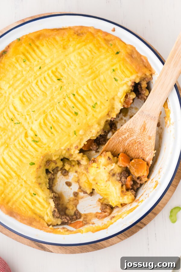 shepherds pie with wooden spoon scooping casserole