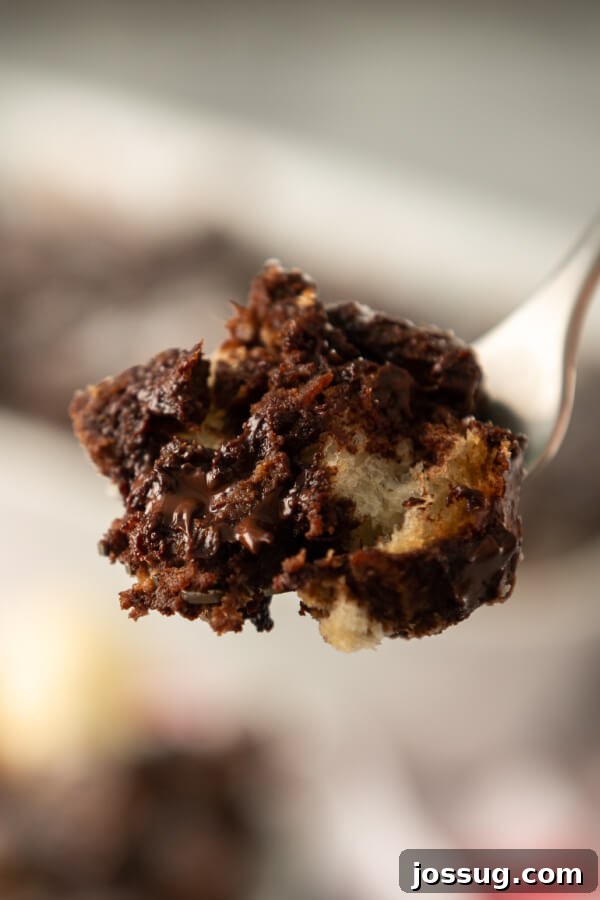 Decadent Chocolate Bread Pudding 9 A single, delectable bite of chocolate bread pudding resting on a fork, showcasing its moist, rich texture.