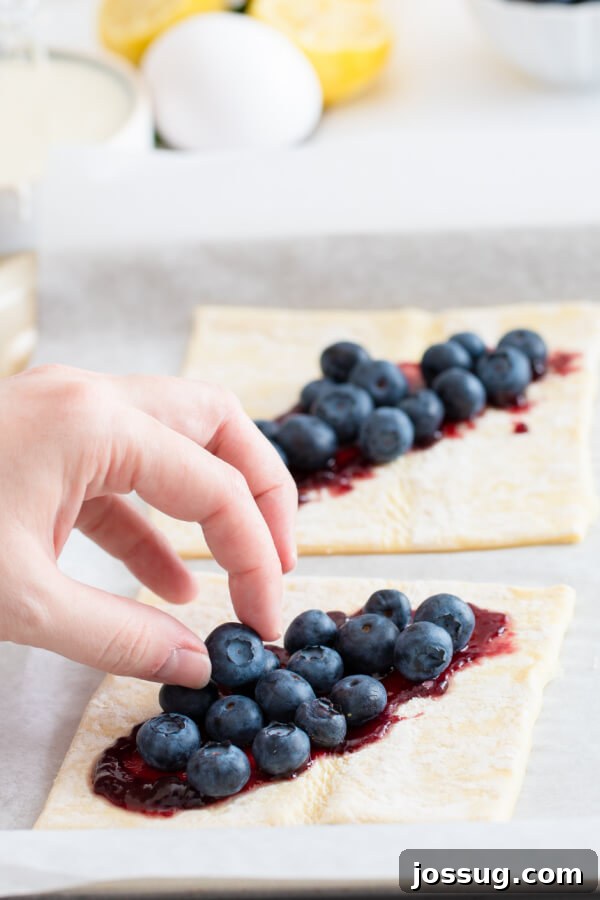 Bright Lemon Blueberry Danish Delight 5 Fresh blueberries carefully arranged on top of blueberry jam spread over puff pastry squares, ready for folding