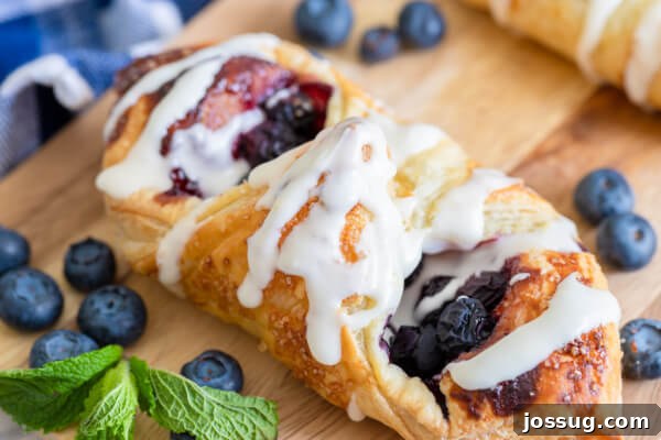 Bright Lemon Blueberry Danish Delight 9 Beautifully arranged lemon blueberry danish on a wooden cutting board with scattered fresh blueberries, ready to serve